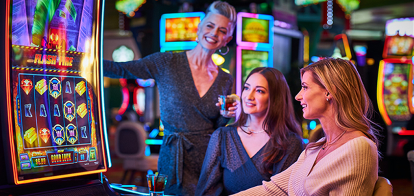 Three friends playing slot machines at THE ROW